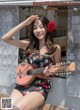 A woman sitting on a bench holding a guitar.