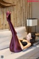 A woman laying on a couch with her legs up.