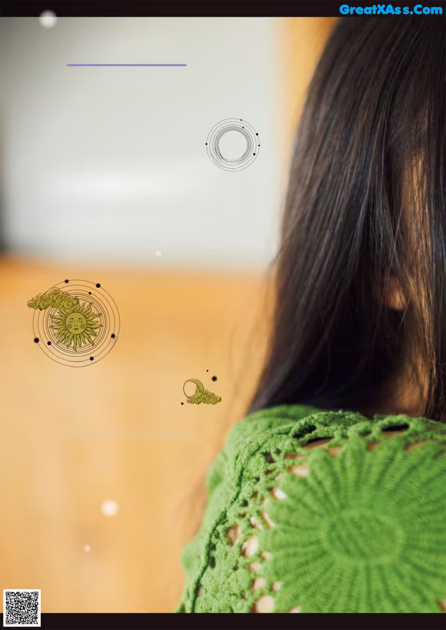 A woman with long black hair wearing a green sweater.