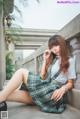 A woman in a school uniform sitting on a ledge.