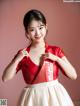 A woman in a red and white dress posing for a picture.