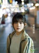 A young woman standing in the middle of a city street.