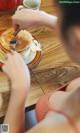 A woman sitting at a table with a plate of pancakes.