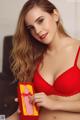 A woman in a red bra holding a red box.