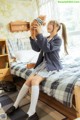 A woman sitting on a bed holding a teddy bear.